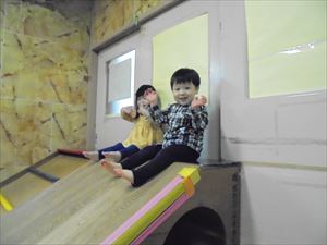 室内滑り台で遊ぶ1歳児