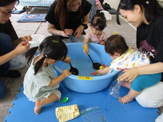 水ヨーヨーや金魚の玩具をすくっているところ