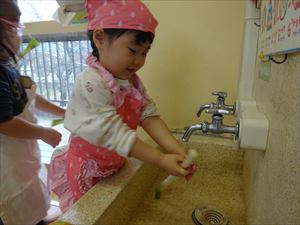 野菜を洗う３歳児